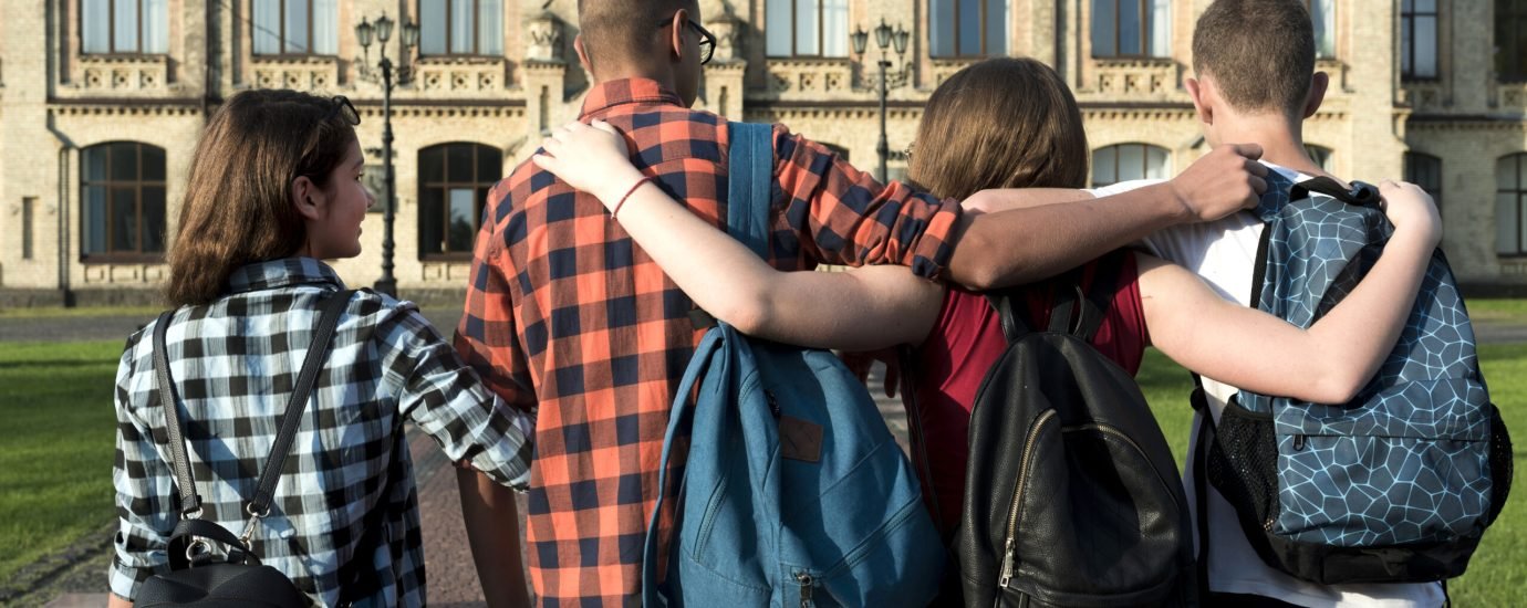 back-view-medium-shot-hugging-teenagers-going-highschool[1]